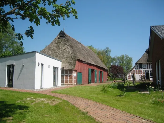 Blick auf den Innenhof von mehreren restaurierten Fachwerkhäusern. Eines hat einen modernen Anbau.